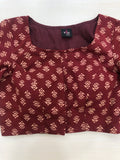 A multicolored cotton blouse by VIKA Boutique is displayed flat on a light surface. This blouse features a vibrant floral pattern, a square neckline, and 3/4 sleeves.
